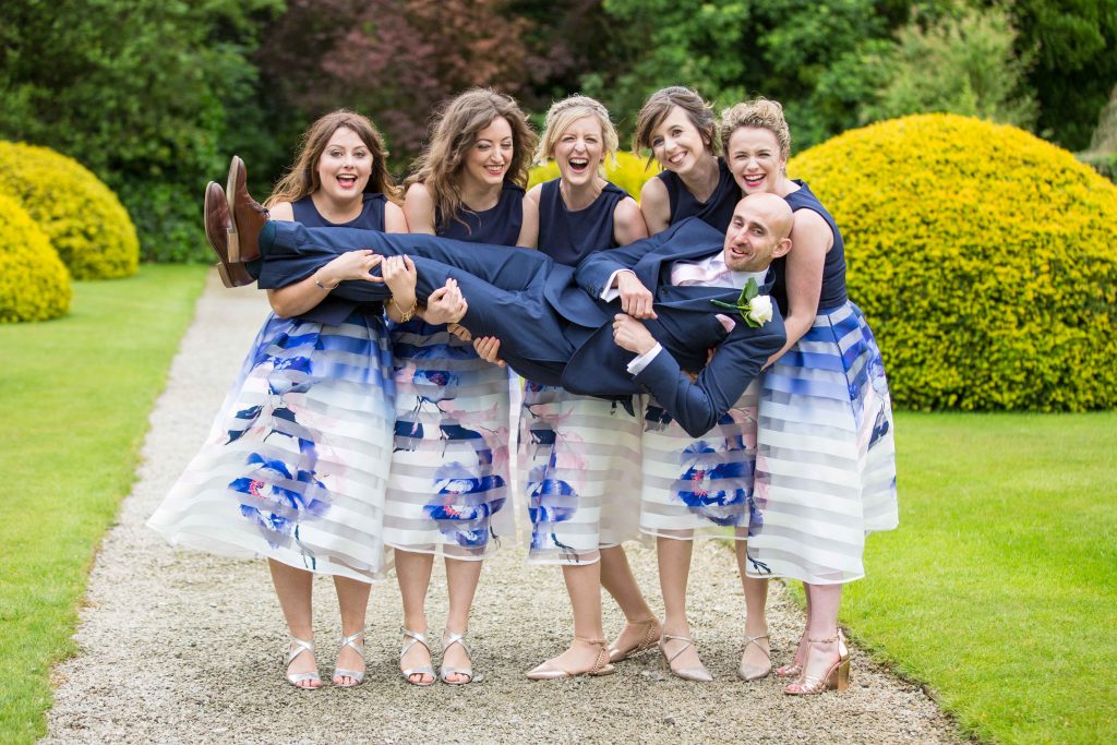 Bridesmaids carrying the groom
