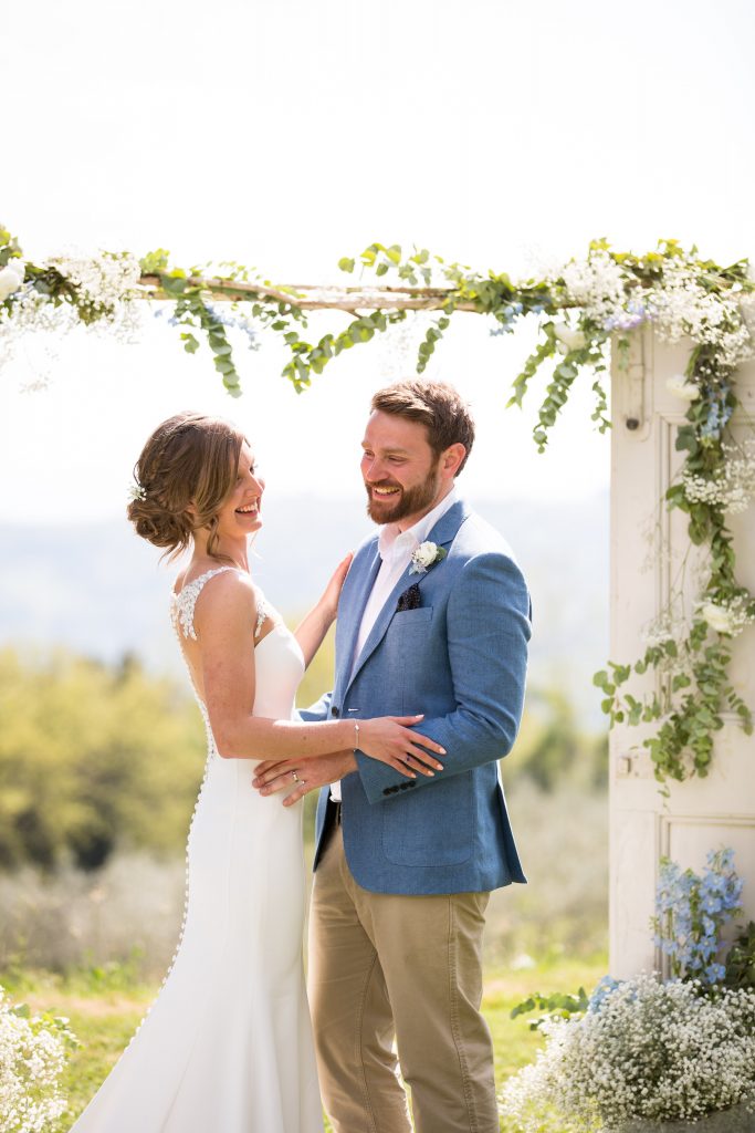Bride and groom laughing and celebrating after their wedding at a 17th-century villa in the Tuscany hills, near Volterra, Italy.